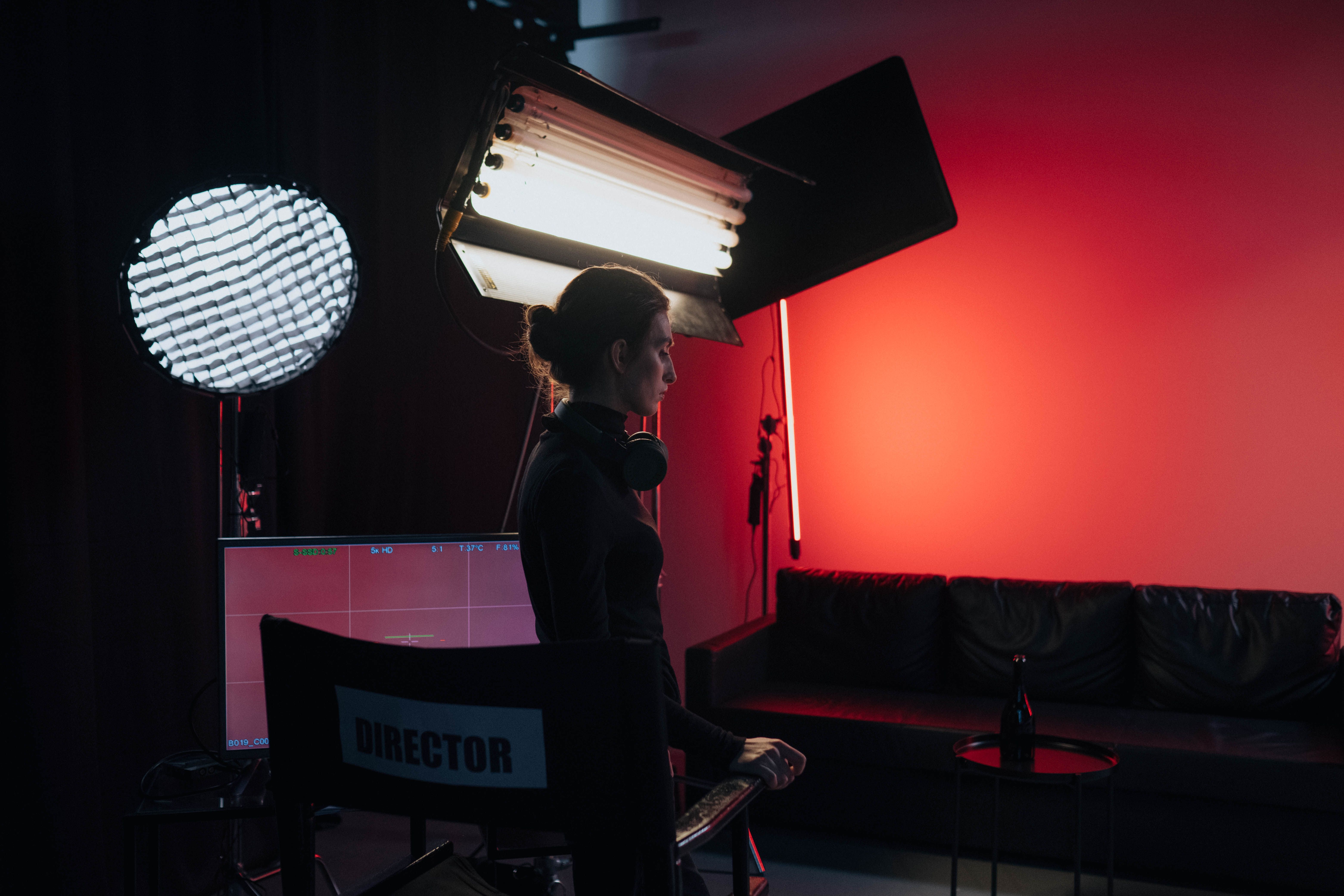 A director in a studio setting with lighting and equipment, creating a cinematic atmosphere