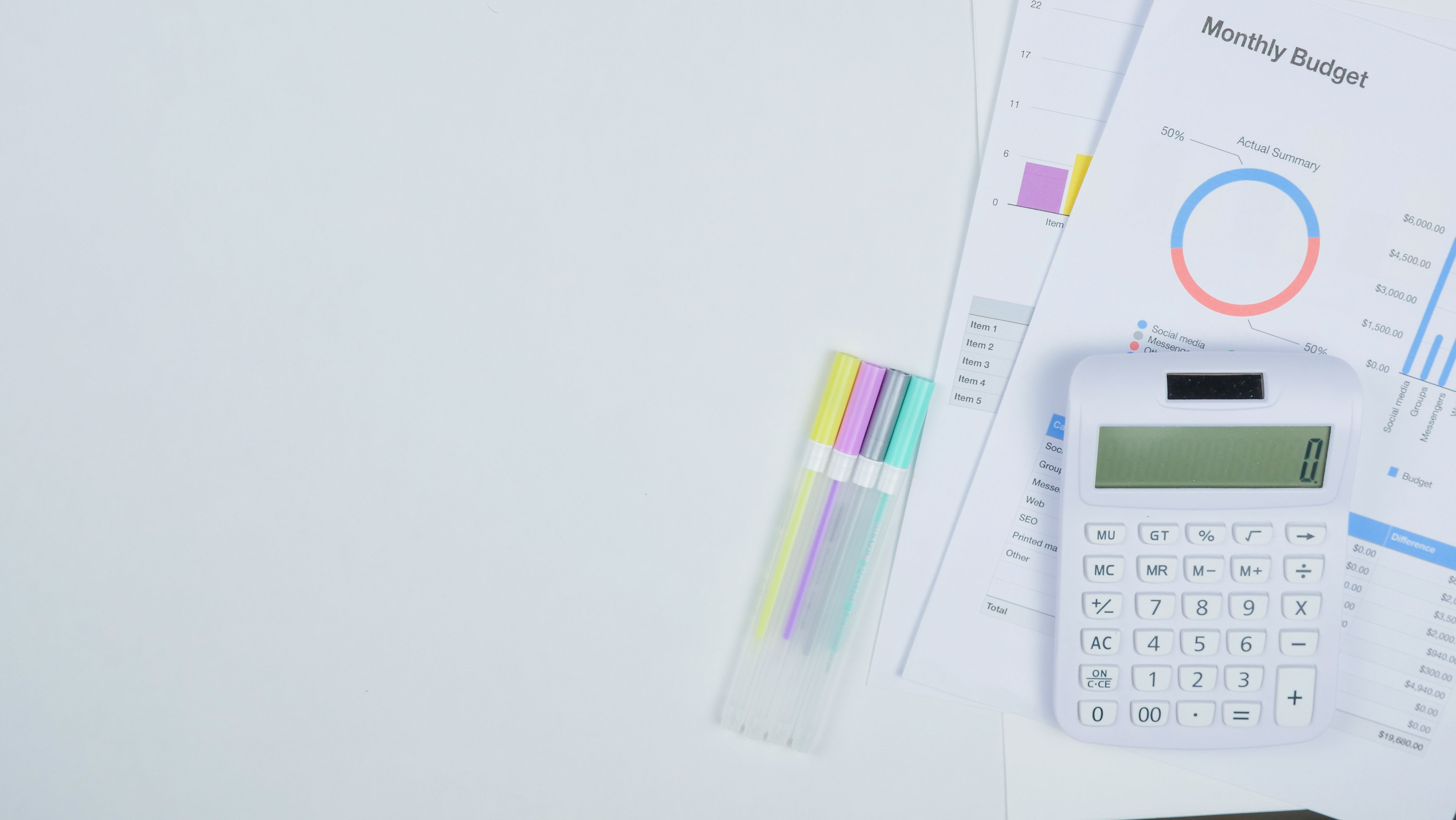 Minimalist office desk with a calculator, budget planning documents, and colorful pens