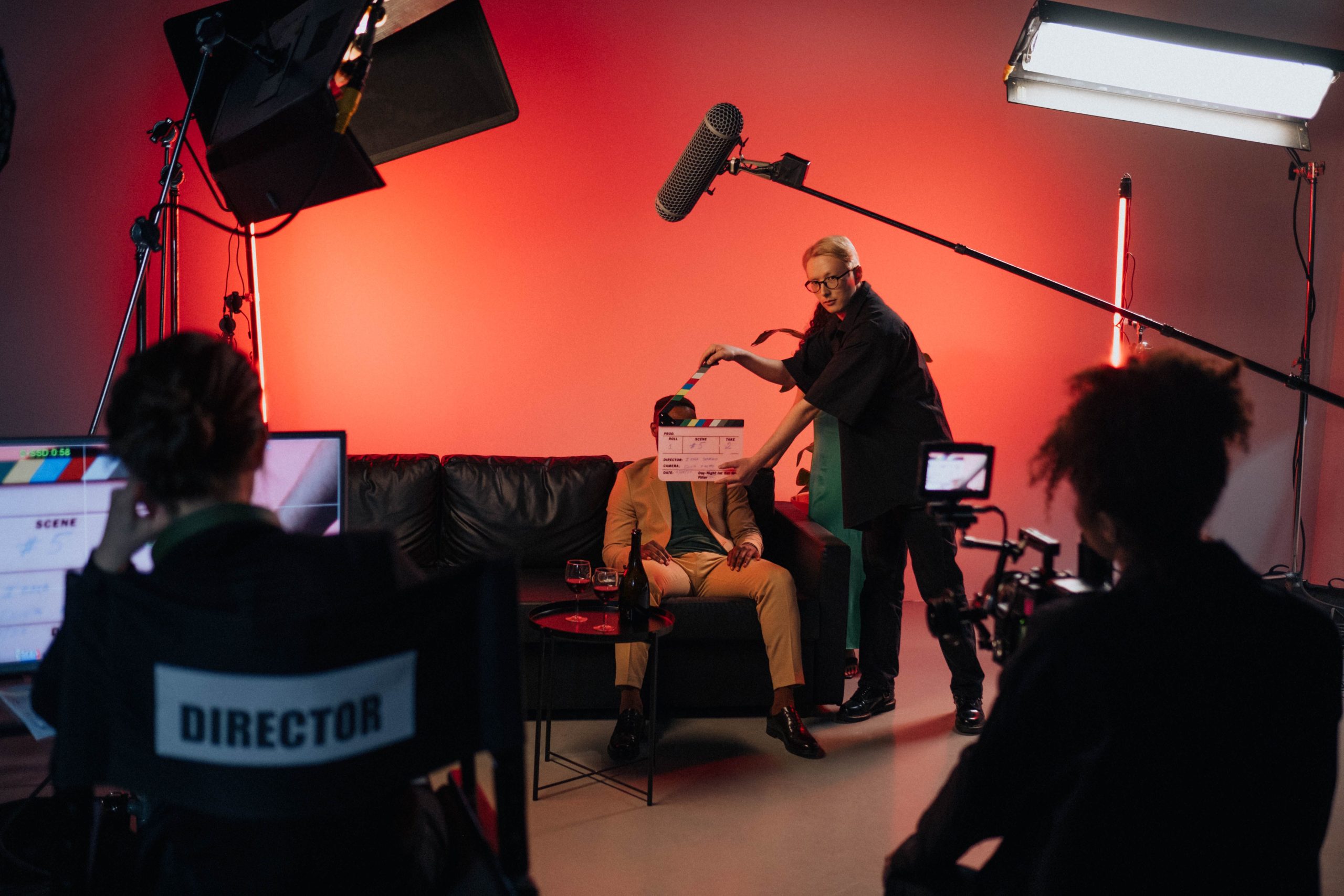 A behind-the-scenes film crew setting up a scene indoors with lighting equipment