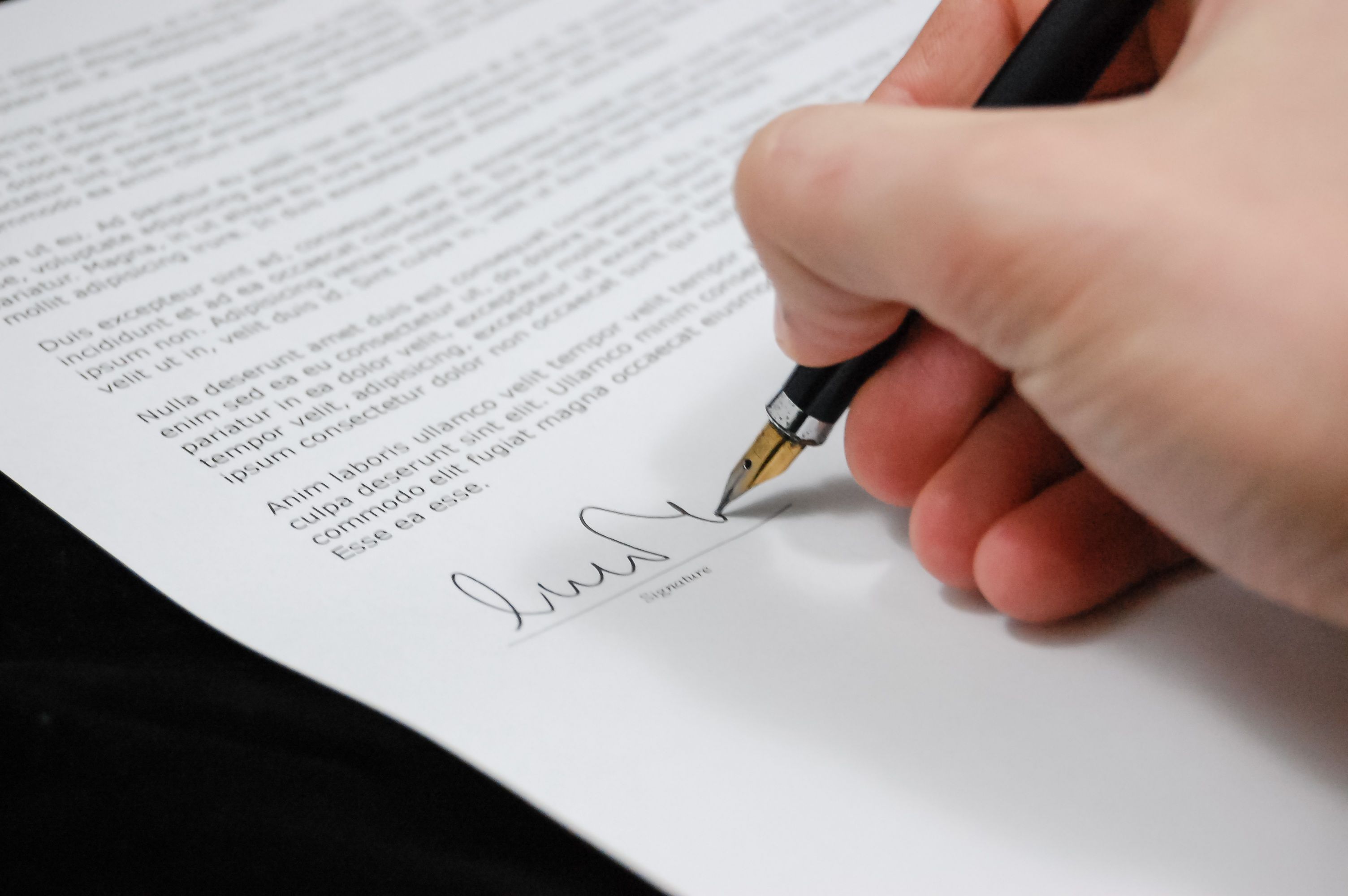 Hand signing a legal contract with a fountain pen, illustrating litigation funding terms