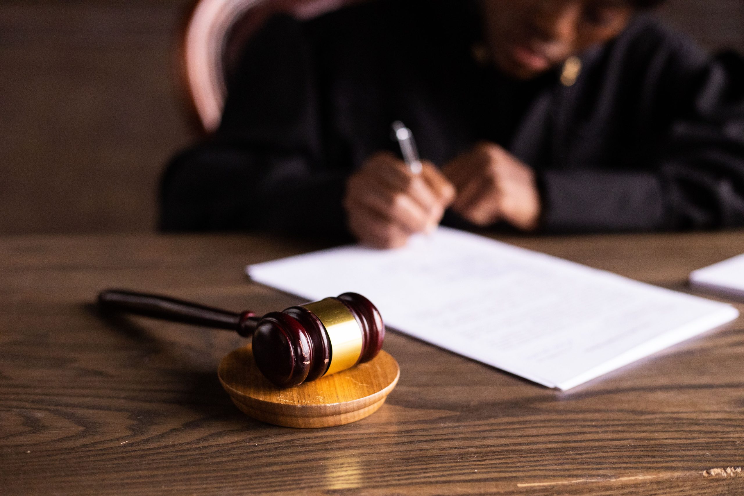 Judge signing legal documents beside a gavel, illustrating the litigation process and court decisions.