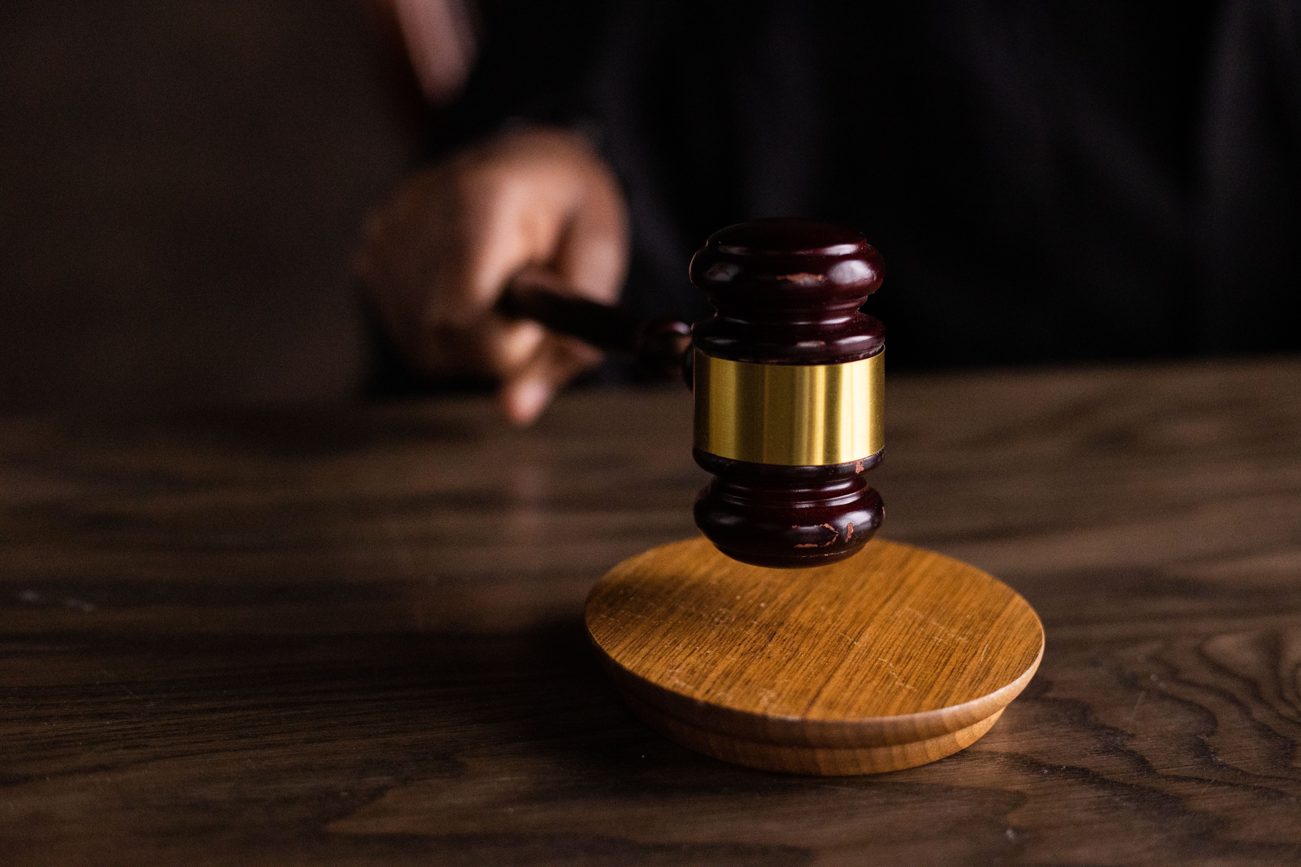Wooden gavel striking a sound block in a courtroom, symbolizing a lawsuit funded by litigation finance