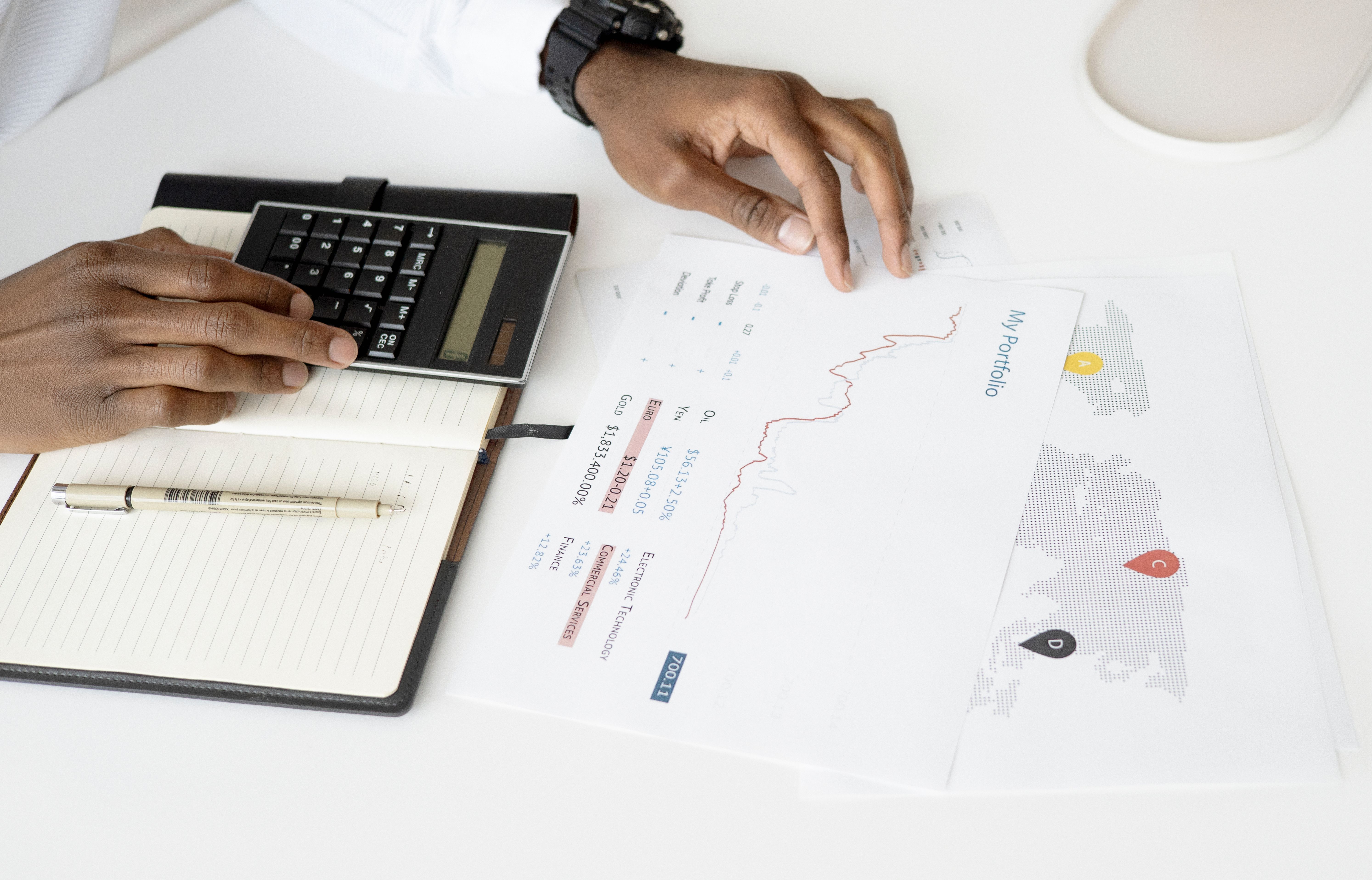 Person analyzing financial documents with a calculator, representing investor return and risk analysis.