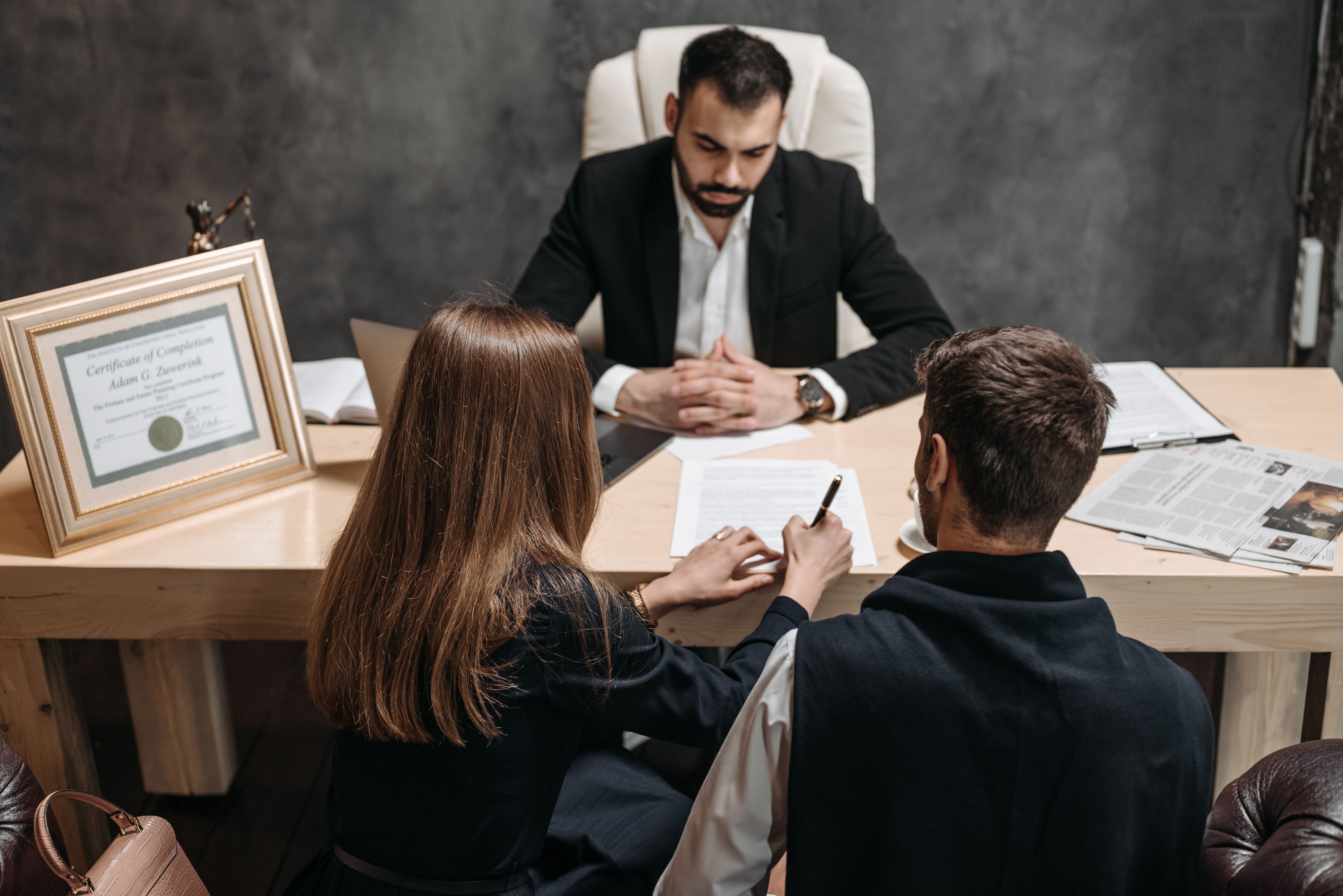 Lawyer discussing case documents with clients in an office, representing legal case evaluation.