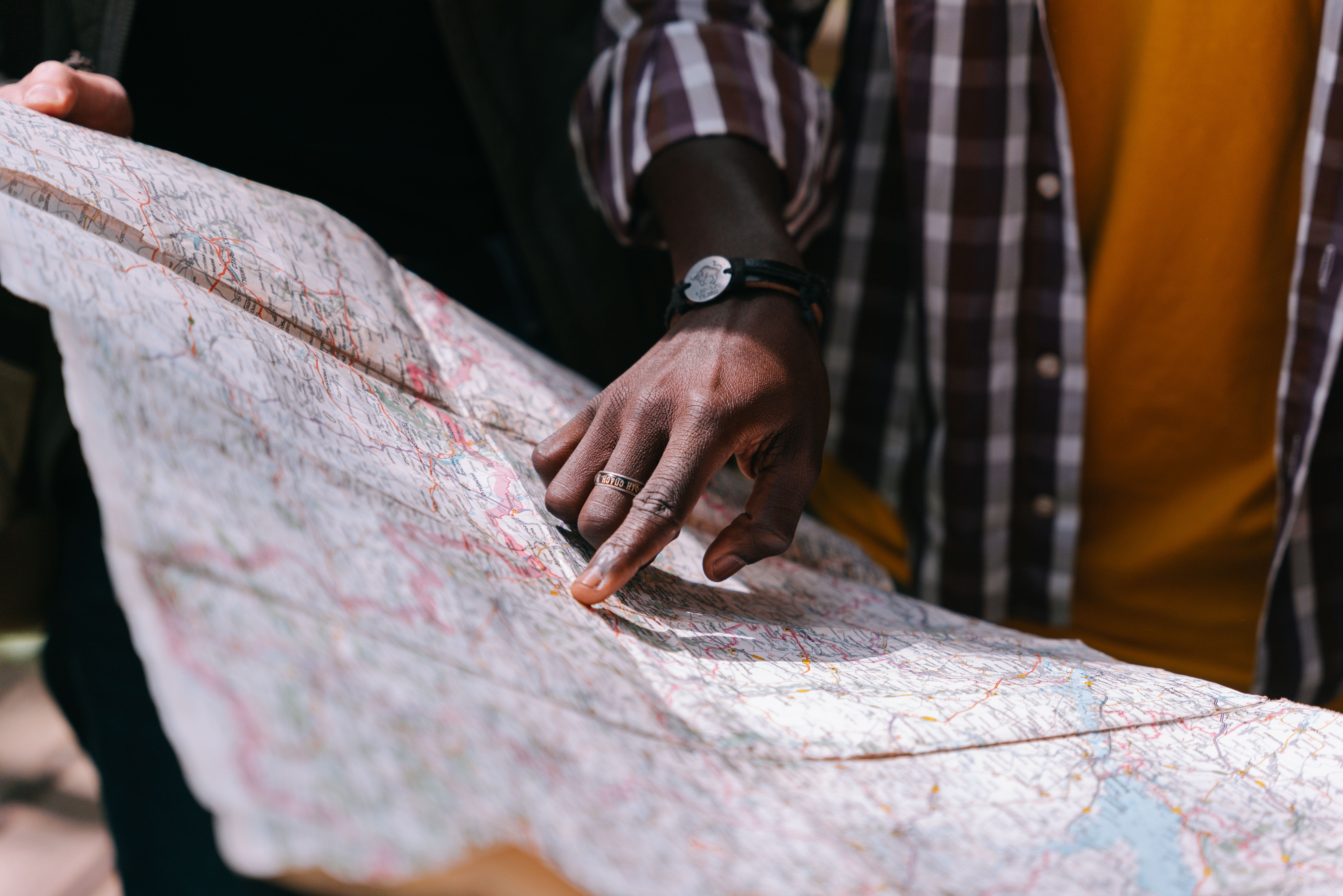 A hand pointing at a detailed map highlighting regional districts and boundaries